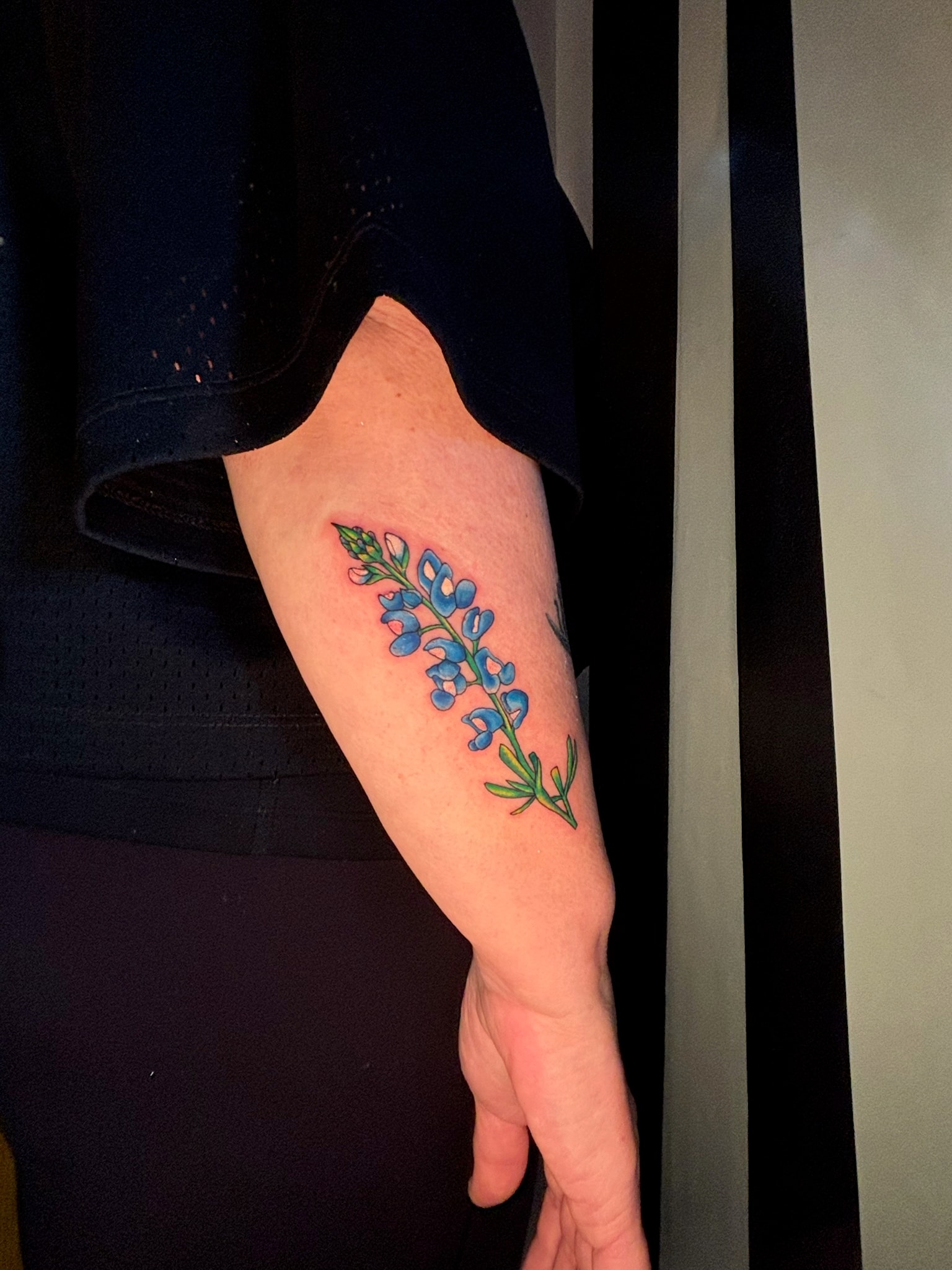 Blue flower vine tattoo on arm, fine line