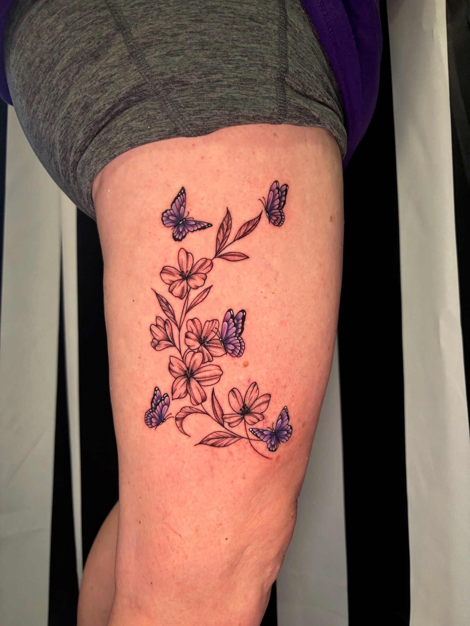 Purple butterflies and pink flowers vine tattoo on thigh, traditional color
