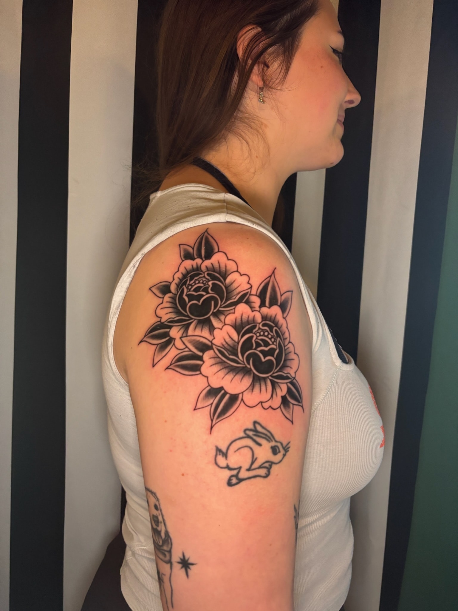 Black and grey peony flowers shoulder tattoo with small running rabbit below