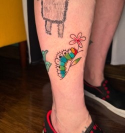 Colorful hummingbird and flower tattoo on leg