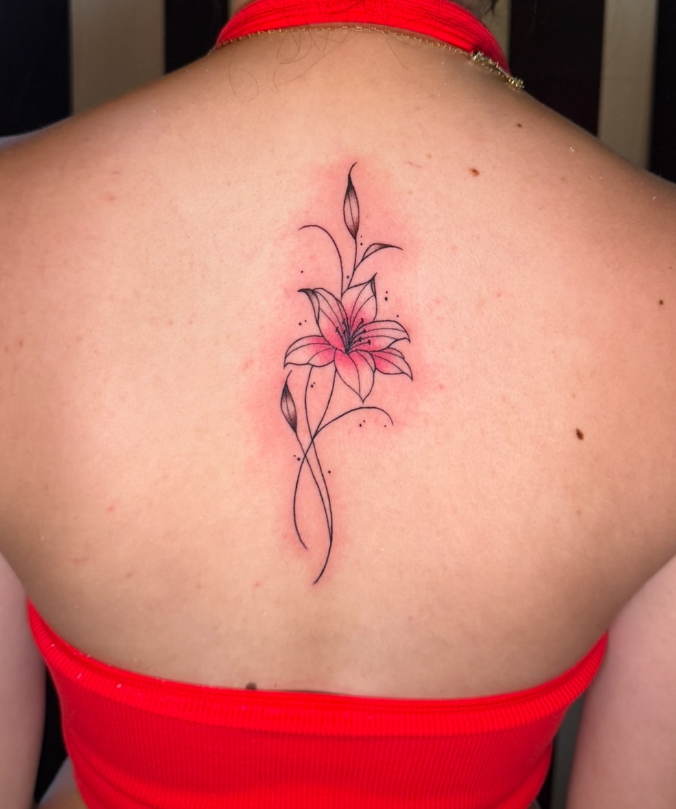 Delicate pink lily flower tattoo on back